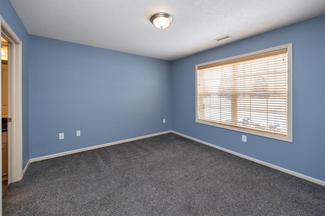 unfurnished room featuring carpet and a textured ceiling