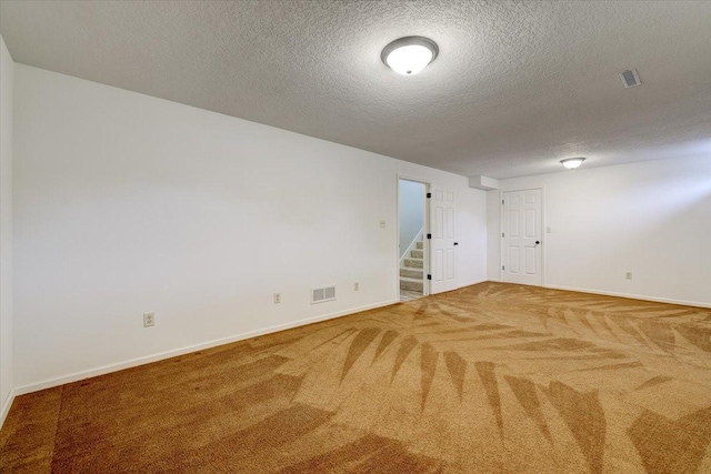 carpeted spare room with a textured ceiling