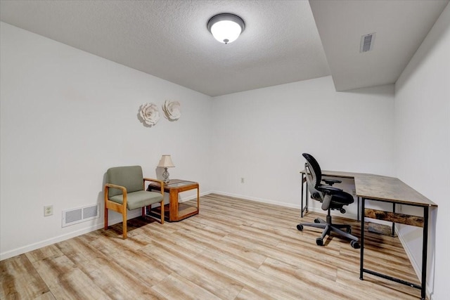 office space with a textured ceiling and light hardwood / wood-style floors