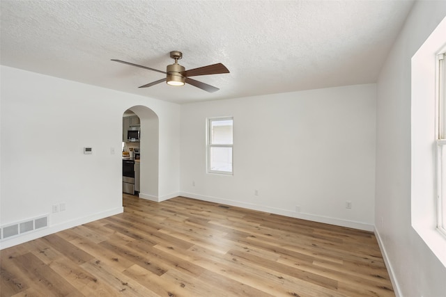 spare room with ceiling fan, a textured ceiling, and light hardwood / wood-style floors