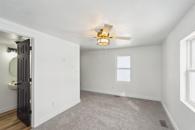 spare room with ceiling fan, carpet floors, and a textured ceiling