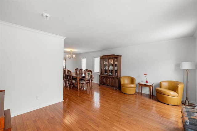 dining space featuring light hardwood / wood-style floors, crown molding, and a notable chandelier