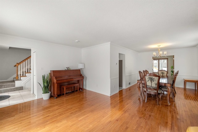 dining room with light hardwood / wood-style floors, a chandelier, and crown molding