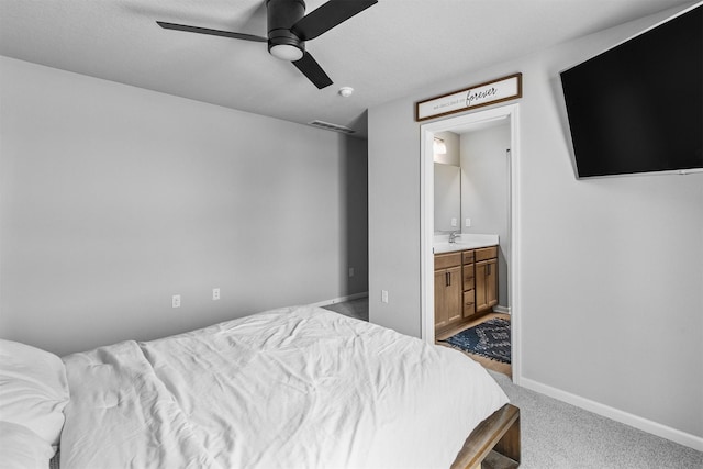 carpeted bedroom featuring ensuite bathroom, ceiling fan, and sink