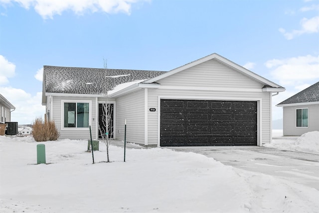 single story home featuring cooling unit and a garage