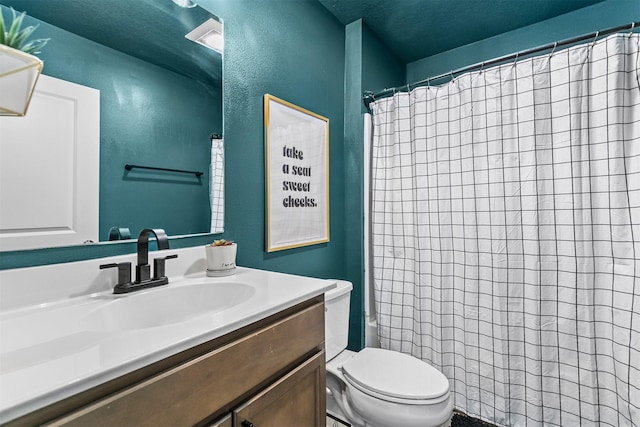 bathroom with curtained shower, vanity, toilet, and a textured ceiling