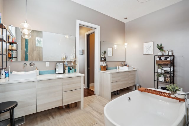 bathroom with vanity, a tub to relax in, and hardwood / wood-style floors