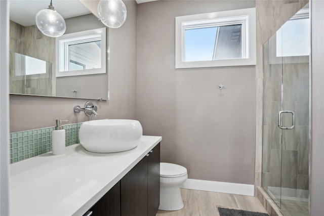 bathroom featuring wood-type flooring, vanity, an enclosed shower, and toilet