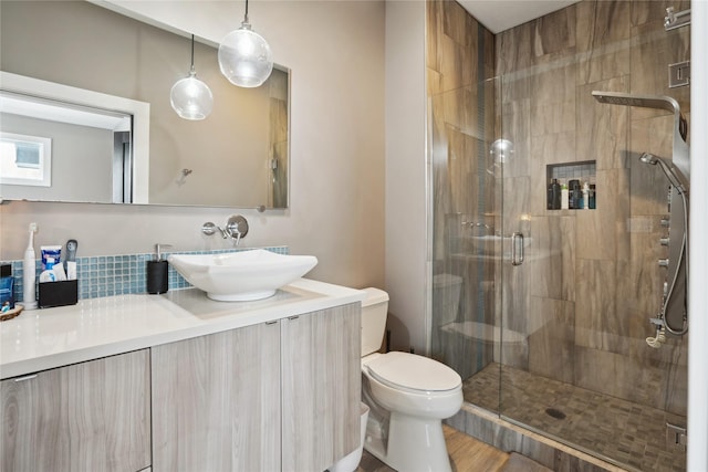 bathroom with toilet, a shower with door, and vanity