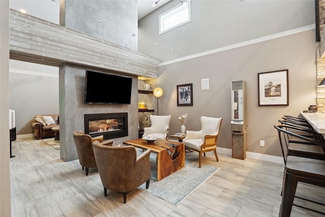 living room with a large fireplace, crown molding, and a towering ceiling