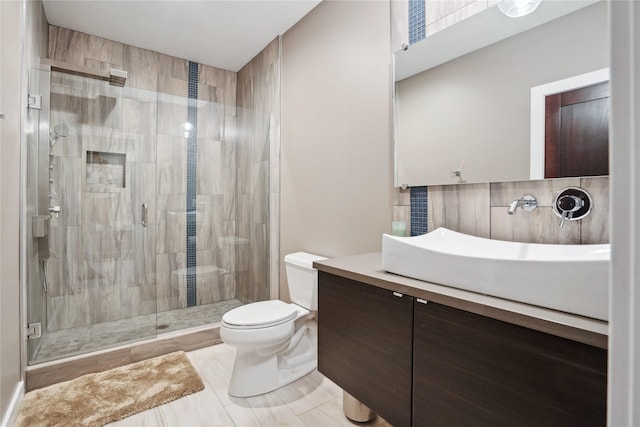 bathroom with toilet, vanity, walk in shower, and backsplash