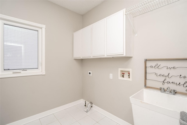 clothes washing area featuring cabinets, hookup for a washing machine, sink, electric dryer hookup, and light tile patterned flooring