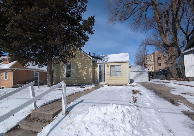 view of front of home with a garage and an outbuilding