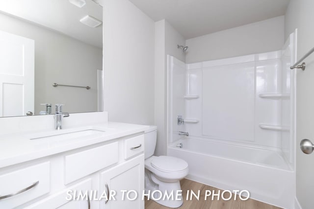 full bath featuring toilet, wood finished floors, vanity, and bathing tub / shower combination