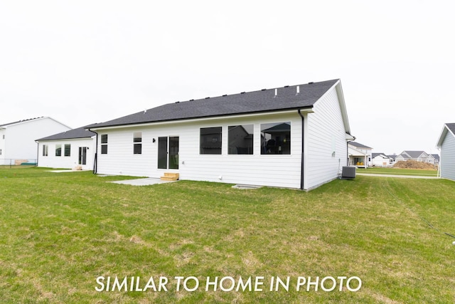 back of property with a yard, a shingled roof, and central AC unit