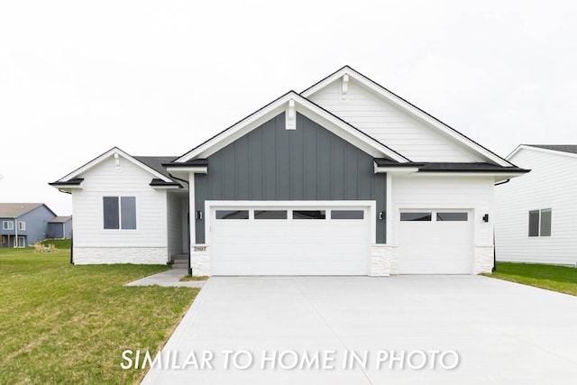 modern farmhouse with a front yard, an attached garage, board and batten siding, and concrete driveway