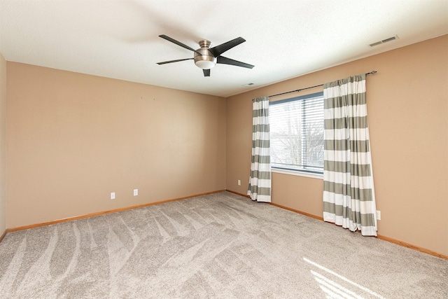 spare room with ceiling fan and light colored carpet