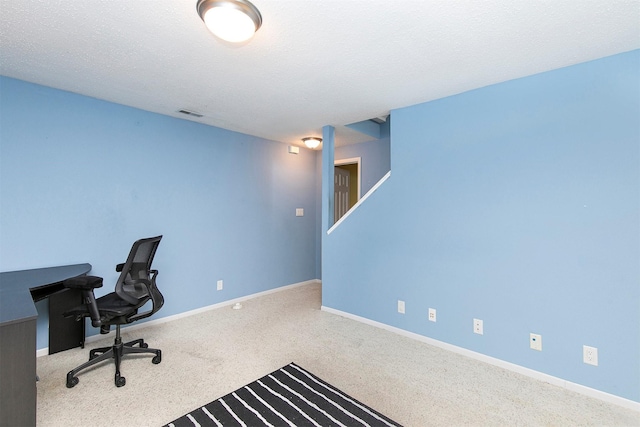 carpeted office with a textured ceiling