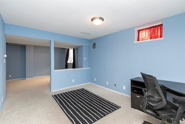 carpeted office space with a textured ceiling