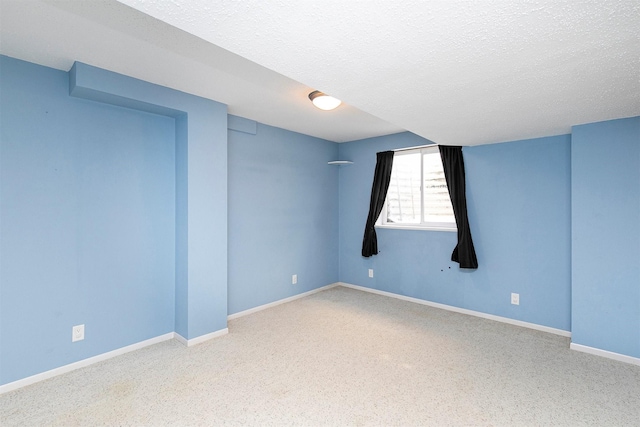 empty room featuring carpet and a textured ceiling