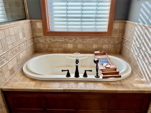 bathroom featuring plenty of natural light and a relaxing tiled tub