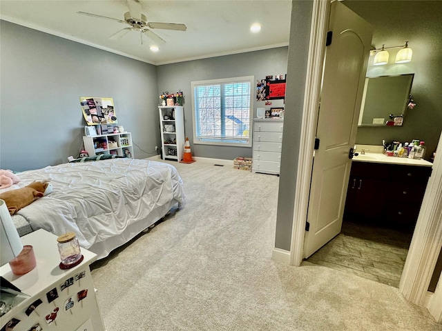 bedroom featuring ceiling fan, sink, crown molding, and light carpet