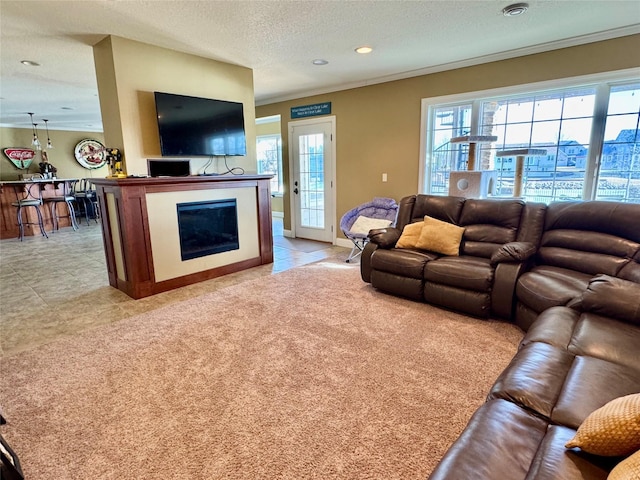 living room featuring ornamental molding, light carpet, and a textured ceiling