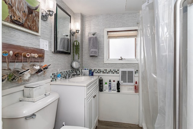 2003 Carroll St, Boone, IA 50036 - bathroom with vanity, decorative backsplash, wood finished floors, and toilet