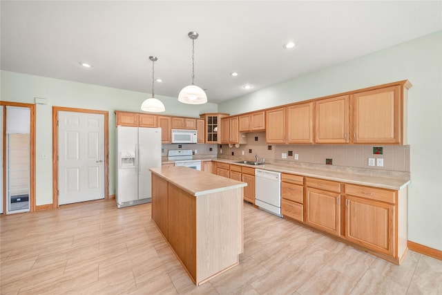 kitchen with white appliances, sink, a center island, pendant lighting, and decorative backsplash