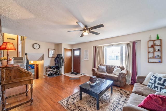 living room with ceiling fan, light hardwood / wood-style flooring, and a textured ceiling