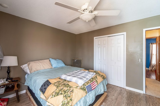 bedroom with a closet, hardwood / wood-style flooring, and ceiling fan