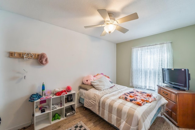 bedroom with ceiling fan and wood-type flooring