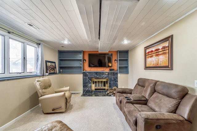 living room with wooden ceiling, a high end fireplace, and carpet flooring