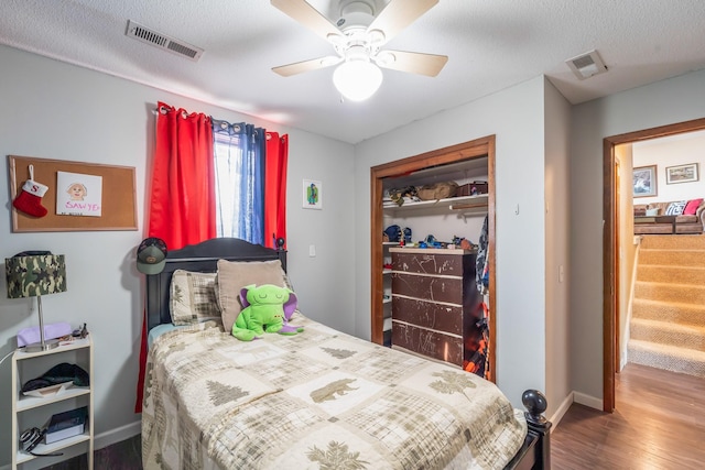 bedroom featuring a textured ceiling, a closet, ceiling fan, and wood-type flooring