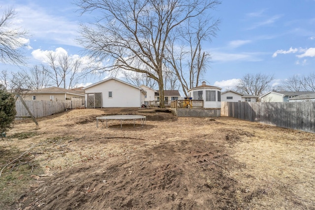 back of house featuring a trampoline and a wooden deck