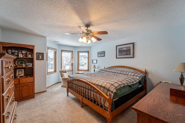 carpeted bedroom with ceiling fan and a textured ceiling