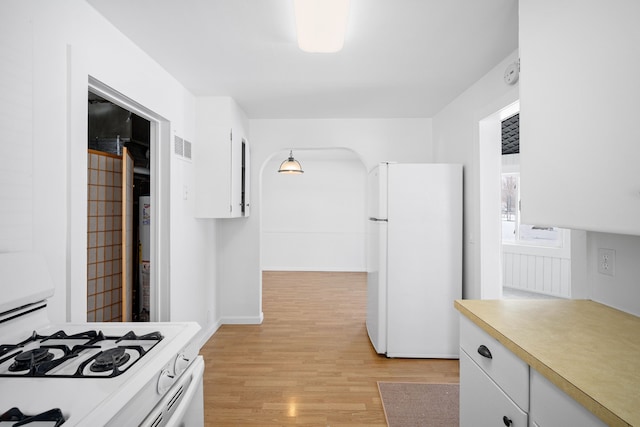 kitchen featuring white cabinetry, white appliances, light hardwood / wood-style floors, and pendant lighting