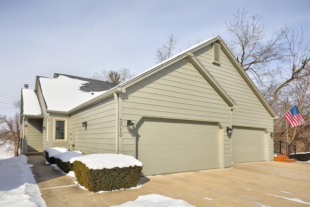 view of snow covered exterior featuring a garage