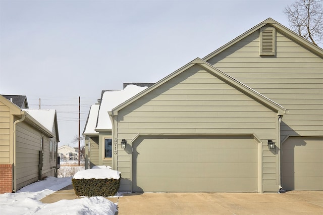 view of snow covered exterior featuring a garage