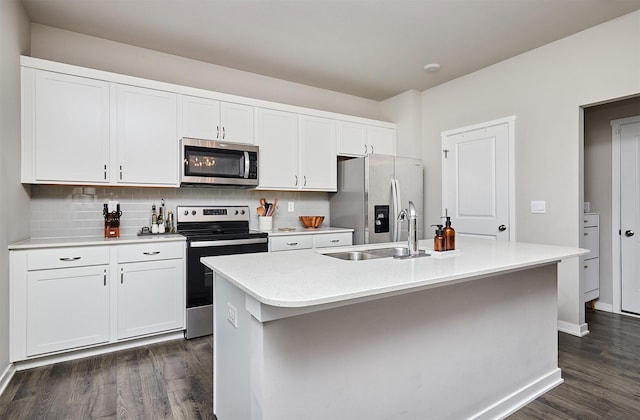 kitchen with appliances with stainless steel finishes, sink, an island with sink, and white cabinetry