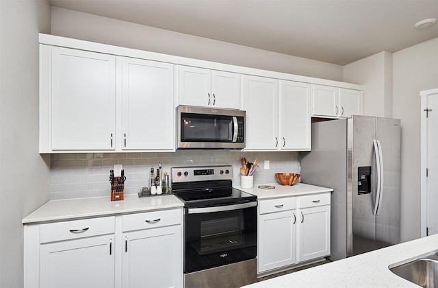 kitchen featuring white cabinetry, stainless steel appliances, and tasteful backsplash