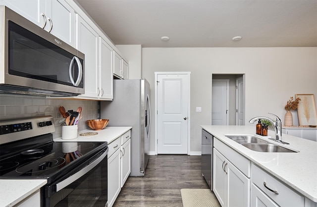 kitchen featuring white cabinets, stainless steel appliances, tasteful backsplash, and sink