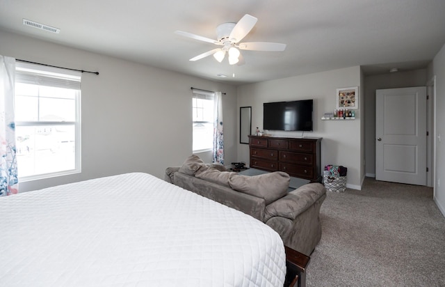 bedroom featuring baseboards, ceiling fan, light colored carpet, and visible vents