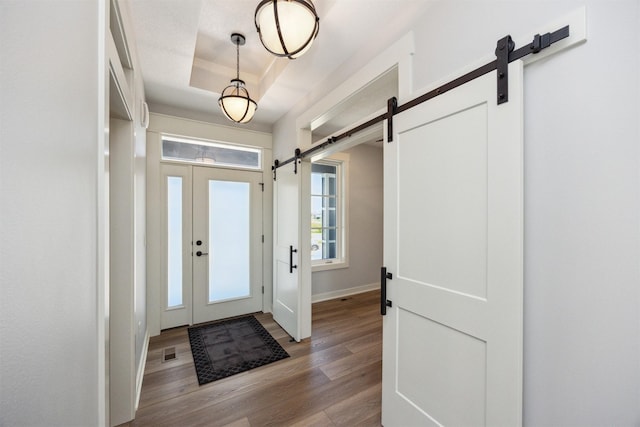 18274 Hidden Knl, Clive, IA 50325 - entryway featuring a barn door, wood finished floors, baseboards, and a raised ceiling