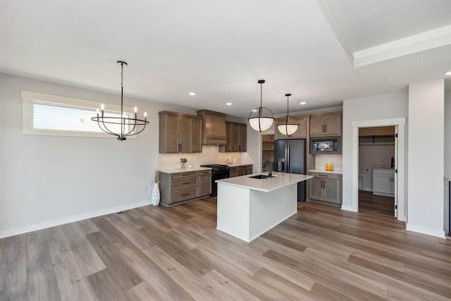 18274 Hidden Knl, Clive, IA 50325 - kitchen with black appliances, a sink, wood finished floors, light countertops, and recessed lighting