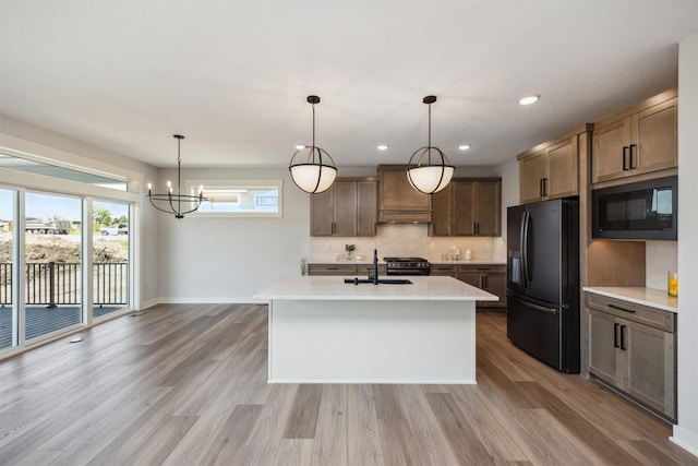18274 Hidden Knl, Clive, IA 50325 - kitchen featuring black appliances, a sink, light wood-style flooring, decorative backsplash, and recessed lighting