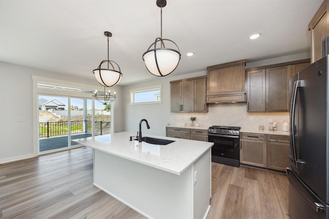 18274 Hidden Knl, Clive, IA 50325 - kitchen featuring freestanding refrigerator, stainless steel gas stove, a sink, light wood-style floors, and tasteful backsplash