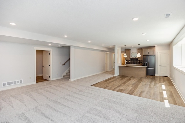 18274 Hidden Knl, Clive, IA 50325 - unfurnished living room with recessed lighting, stairway, baseboards, and light wood-style flooring