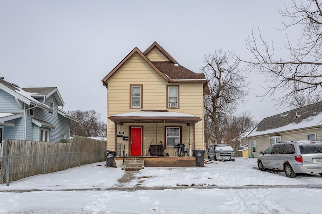 view of front of property featuring fence and a porch