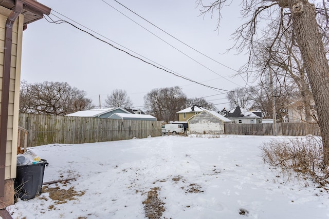 yard layered in snow featuring fence